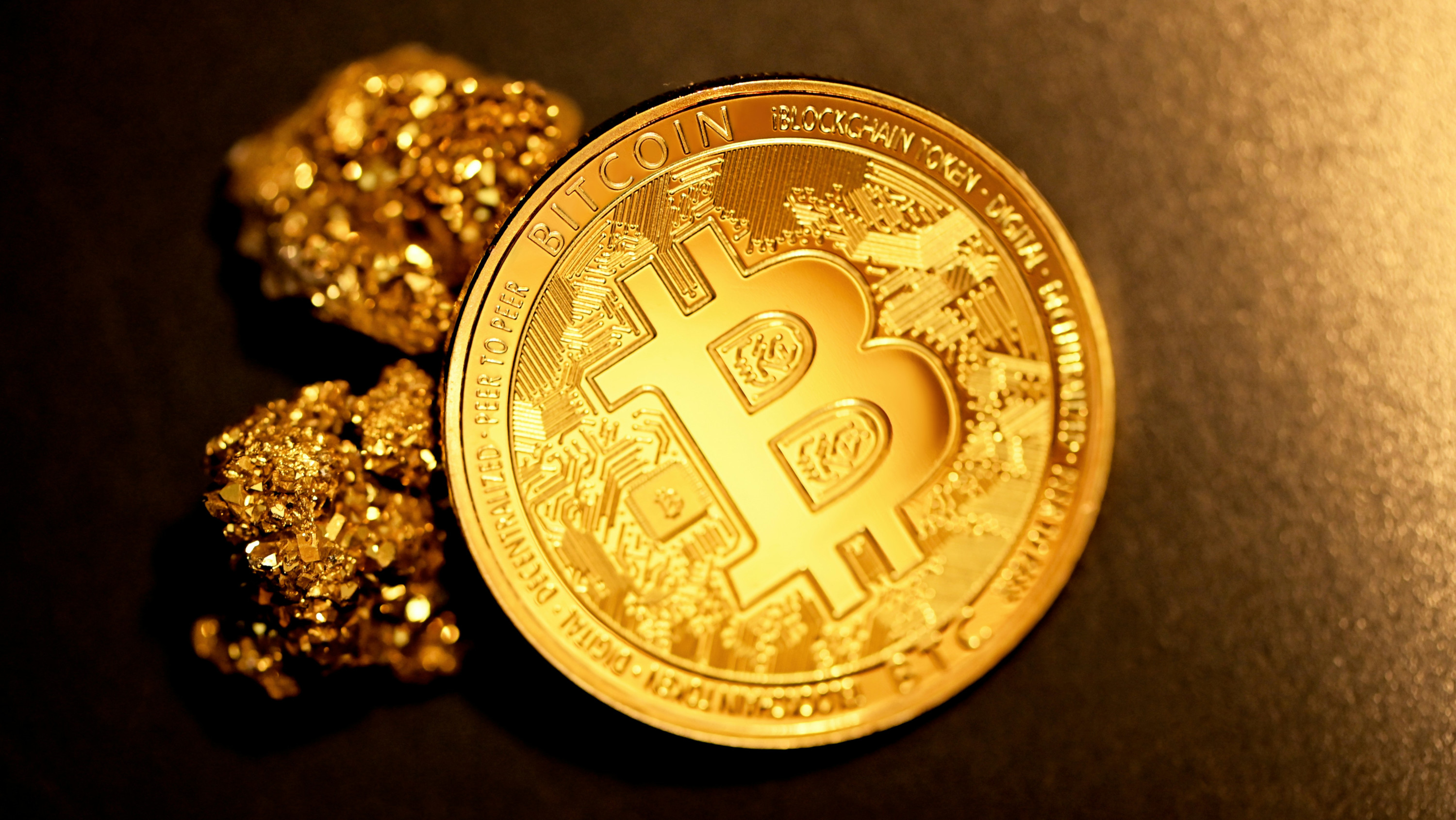 A physical bitcoin token surrounded by gold nuggets